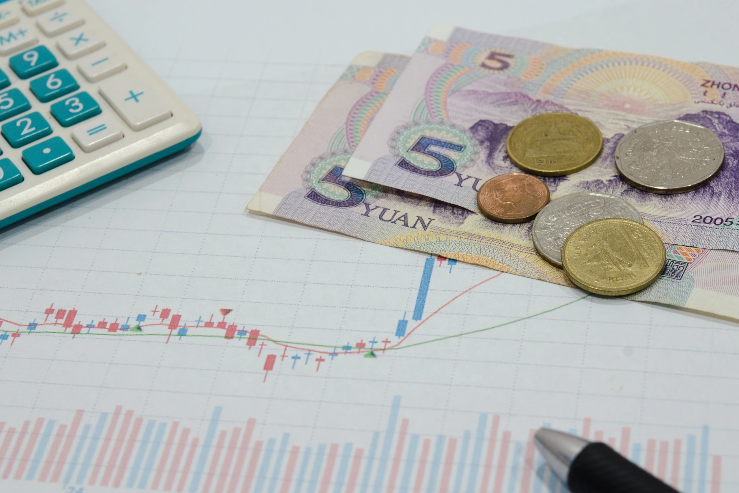 Euro banknotes and coins on a chart, illustrating economic data analysis