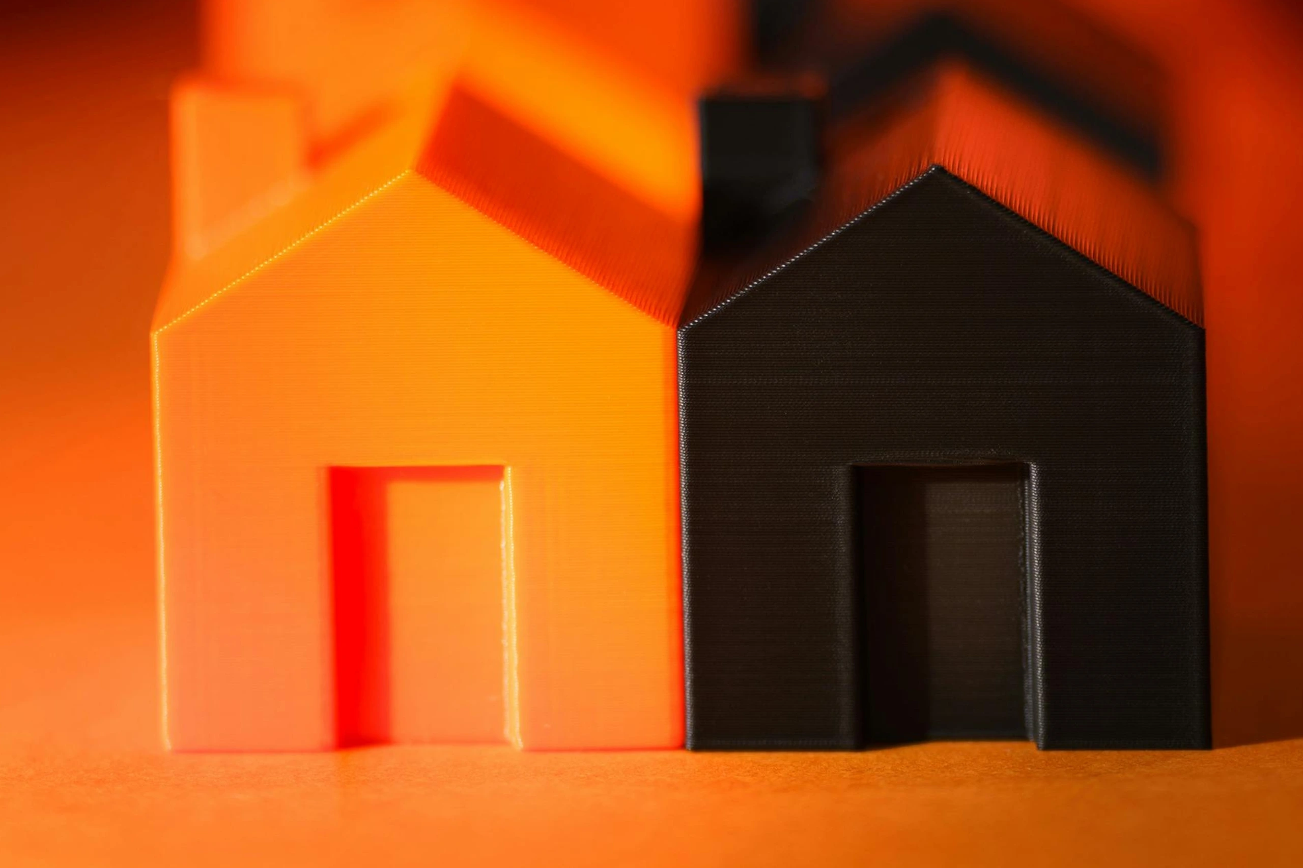 Two miniature house models with orange background