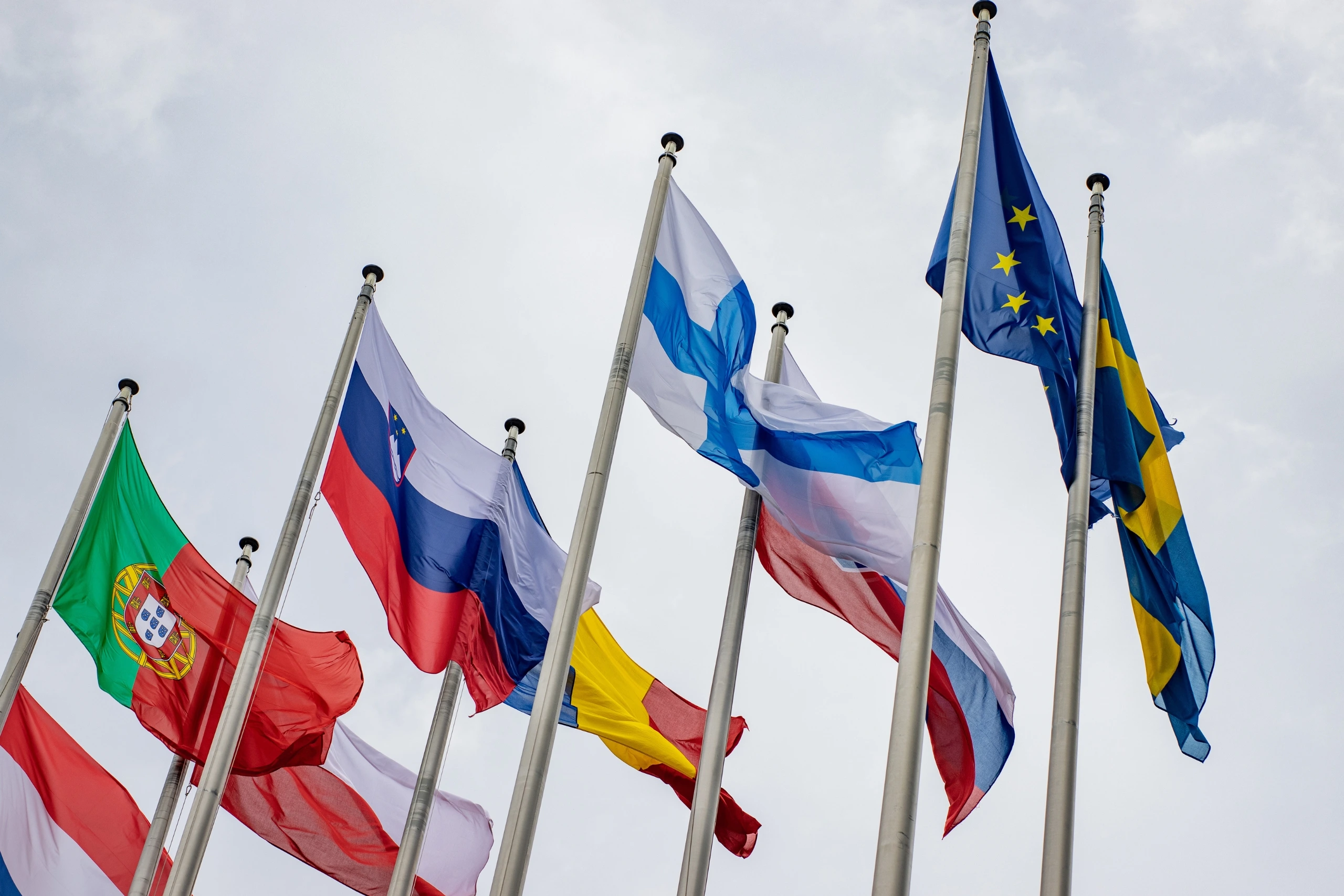 Flags of multiple European countries waving in the sky