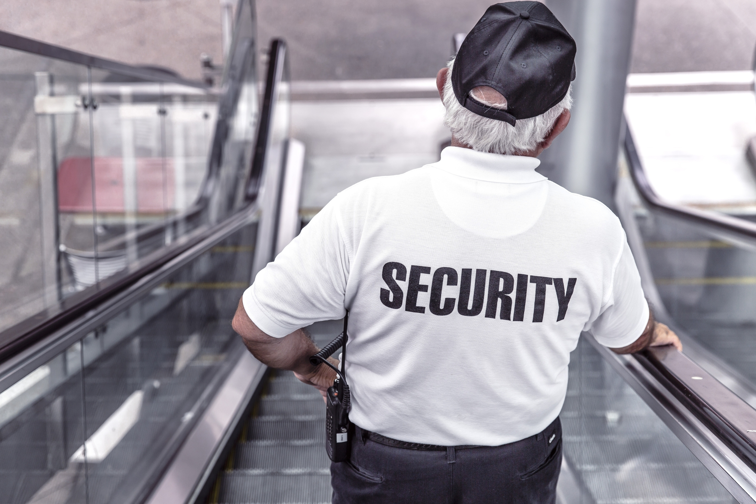 Security guard on an escalator with SECURITY written on the back