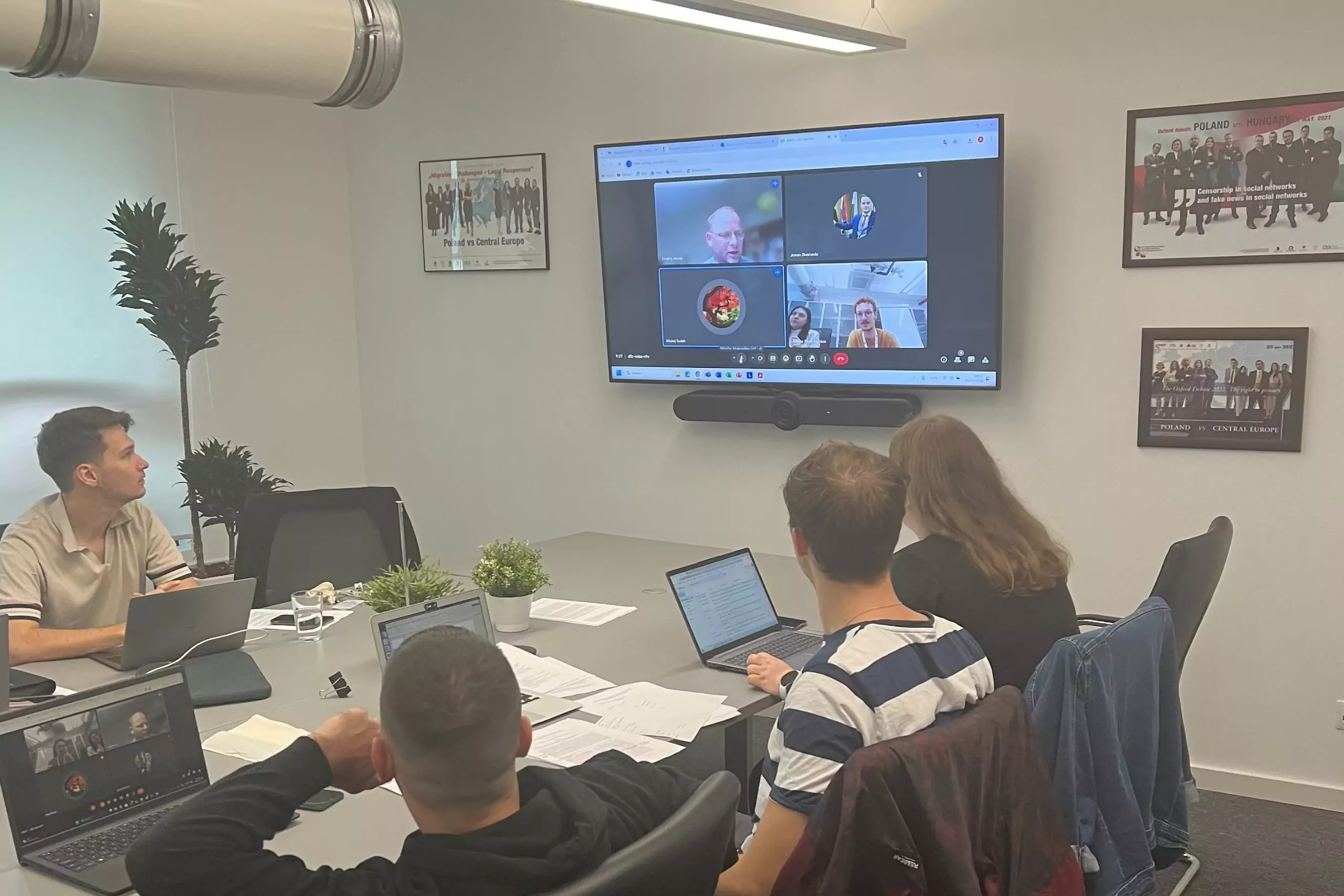 Résztvevők online konferenciát követnek kivetítőn keresztül