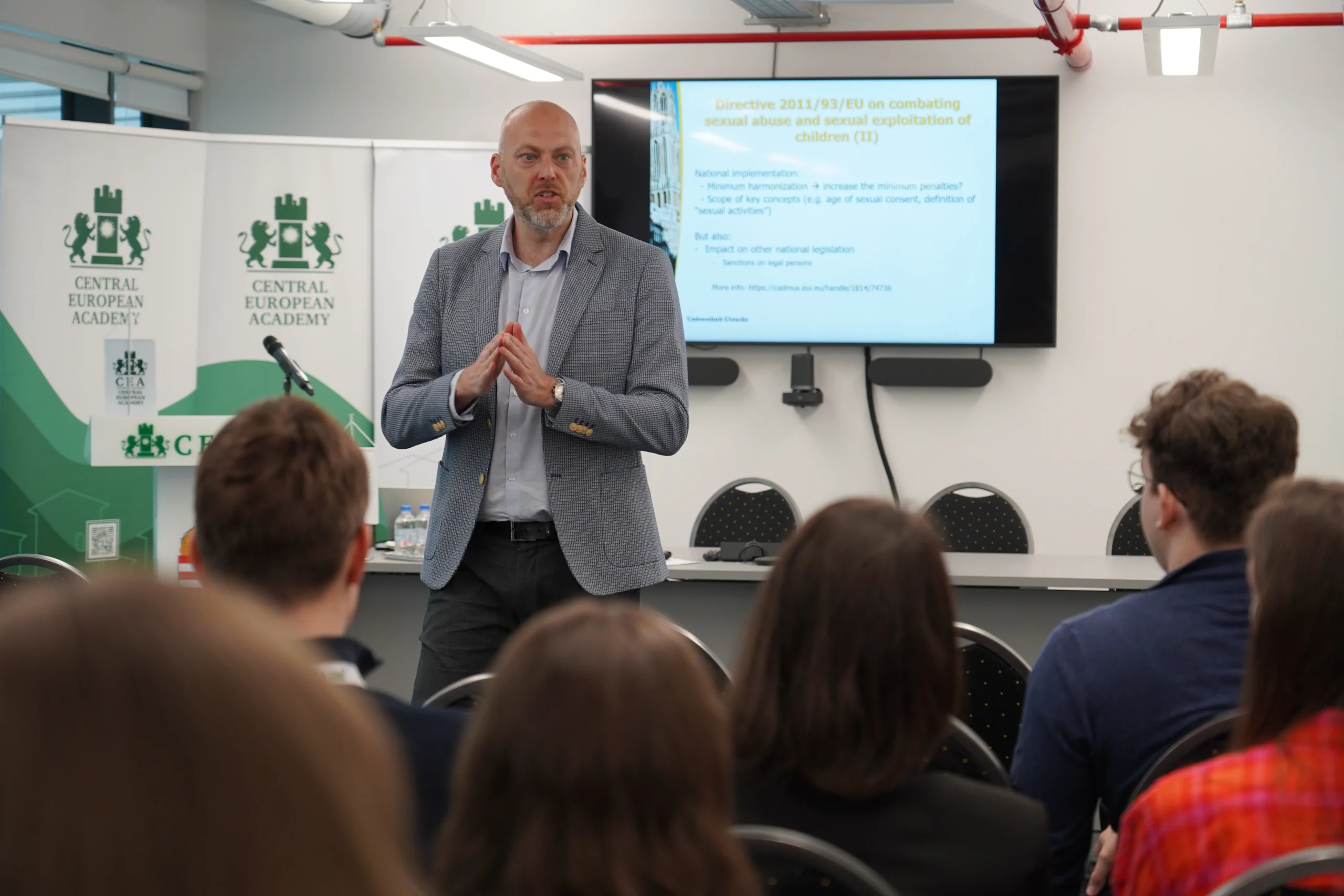 Előadó beszél a CEA pódiumán, hallgatóság előtt