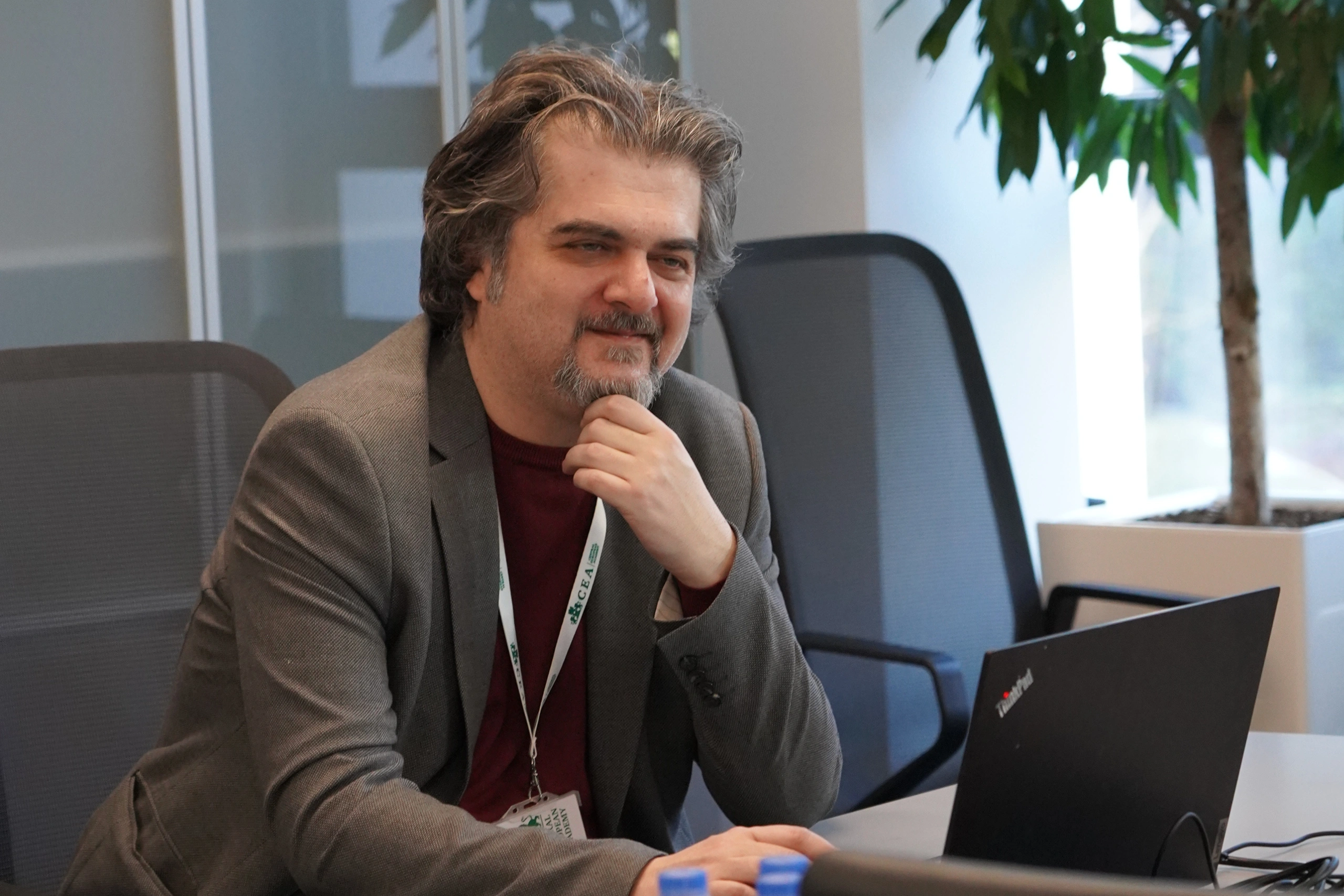 Résztvevő gondolkodó testtartásban ül a tárgyalóban