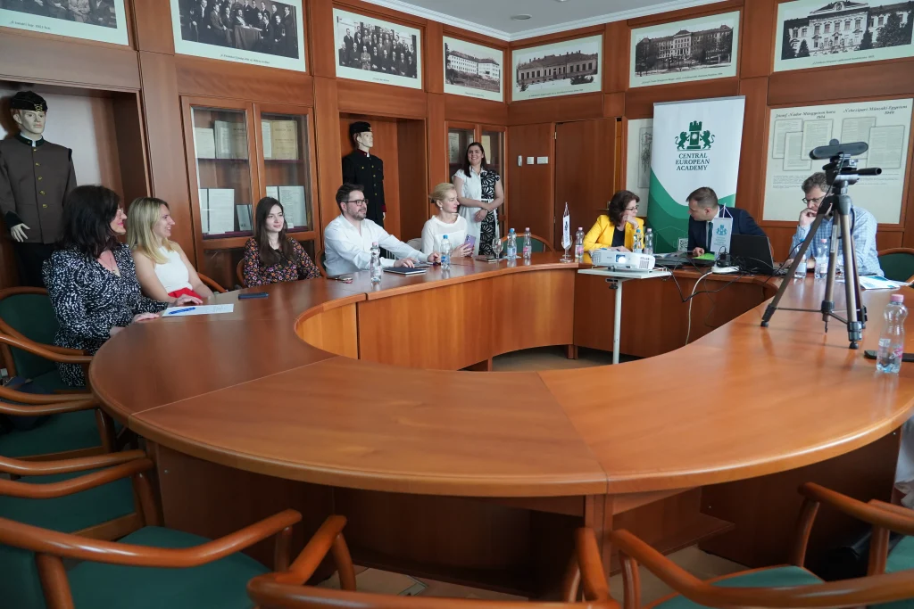 Nagy tárgyalóterem, résztvevők kerekasztal-beszélgetésen.