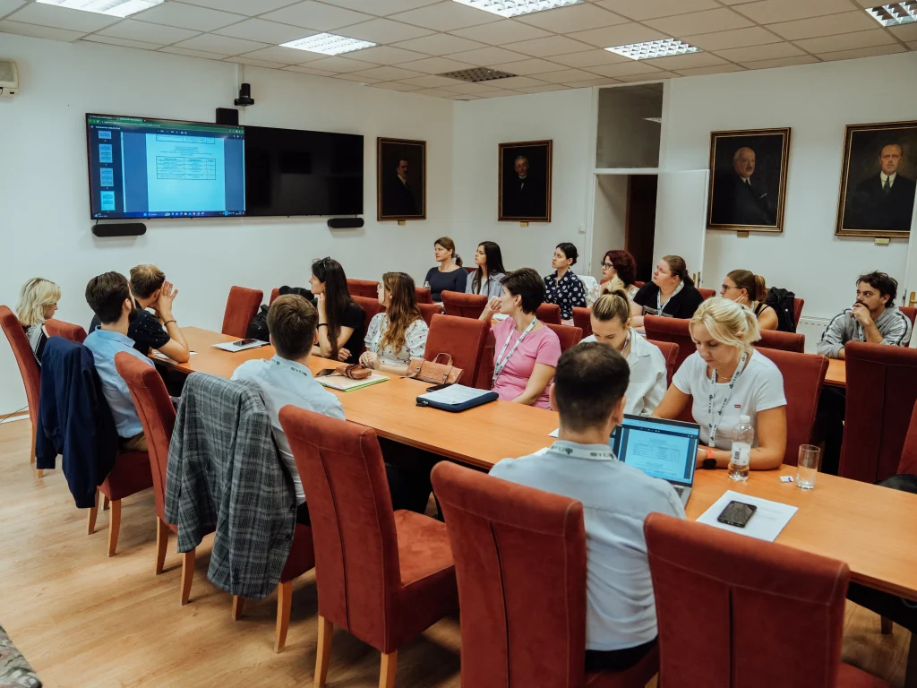 Meeting in a conference room with participants listening to a presentation